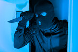 Masked thief peeking around door, break in