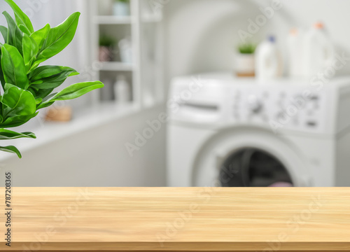 Wood table for display products and blurred laundry room with green plants