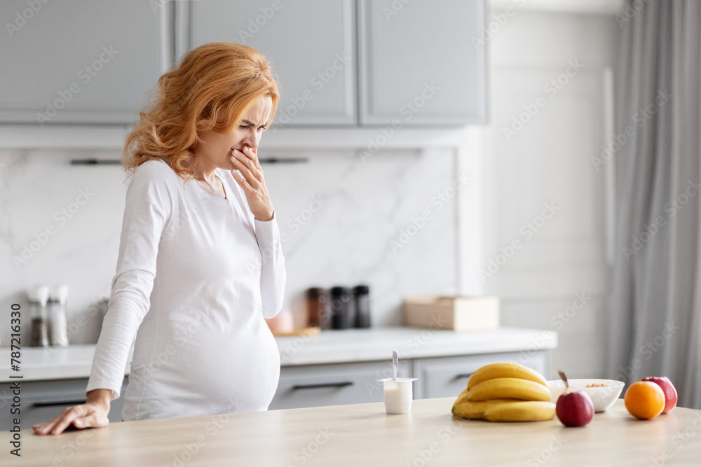 Expectant mother in distress in kitchen, copy space Expectant mother in distress in kitchen, copy space