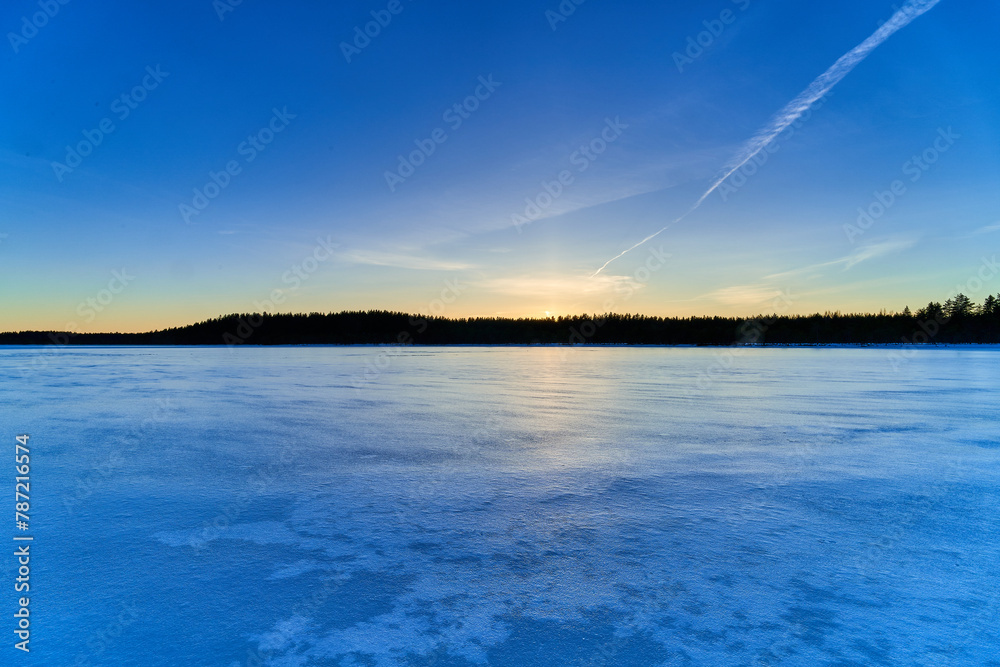 Beautiful winter sunset in small forest lake