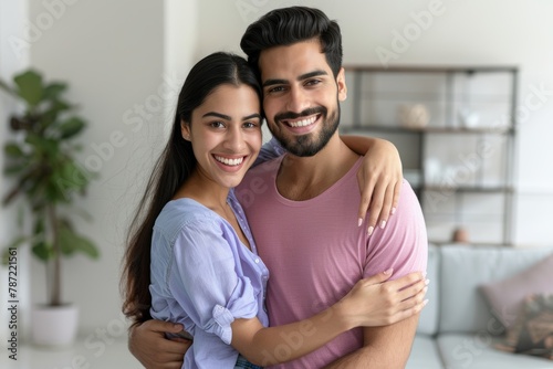 A happy man in his thirties wearing a purple shirt is being held by his wife and the woman he loves, people in love smiling with closed eyes tender man touching his attractive girlfriend