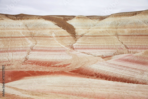 Unique geological feature known as tiger-striped mountains, showcasing layers of sedimentary rock in warm tones that resemble the stripes of a tiger. 