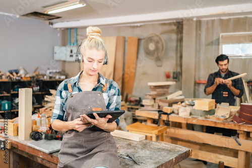 In the carpenter's shop, a professional woman crafts wooden furniture, using tools with skill in her woodwork occupation, showcasing industry prowess.