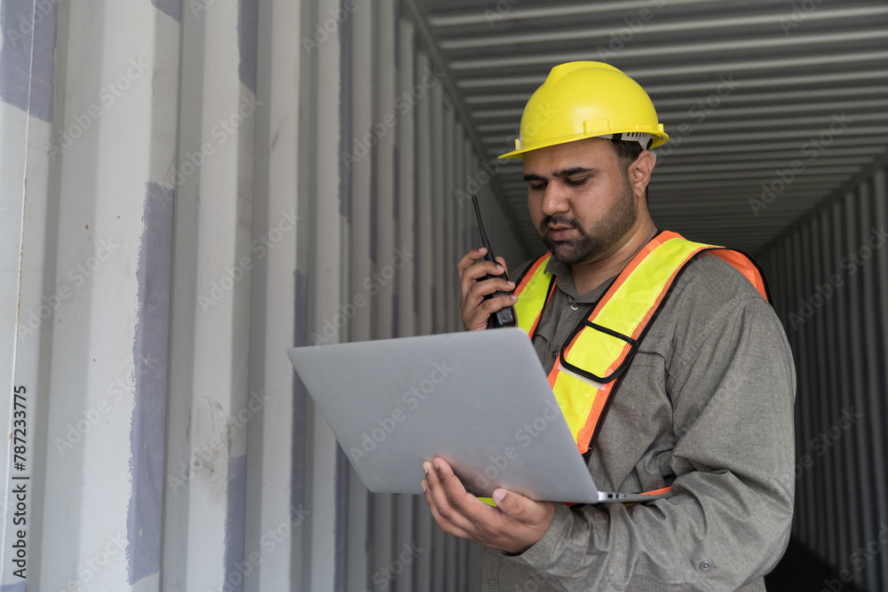 Male container yard worker loading containers box at commercial dock site. Male worker control loading container box from cargo freight ship for import export Male container yard worker loading containers box at commercial dock site. Male worker control loading container box from cargo freight ship for import export