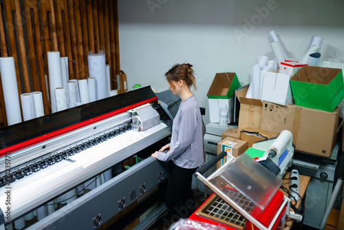 Woman operating machine in printing studio