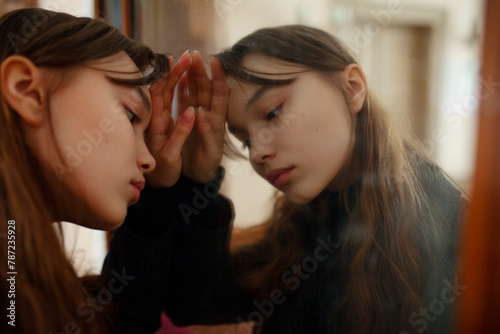 Close-up of pensive young woman leaning against mirror