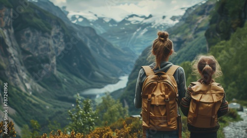 Mother and daughter with backpacks overlooking a valley mountain and river, happy bonding mom and young girl spend carefree holiday vacation hiking adventure outdoor trip, Family traveling activities photo