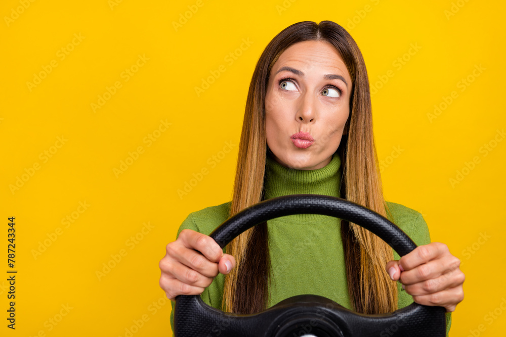 Portrait of minded lady pouted lips hold wheel look empty space isolated on yellow color background Portrait of minded lady pouted lips hold wheel look empty space isolated on yellow color background