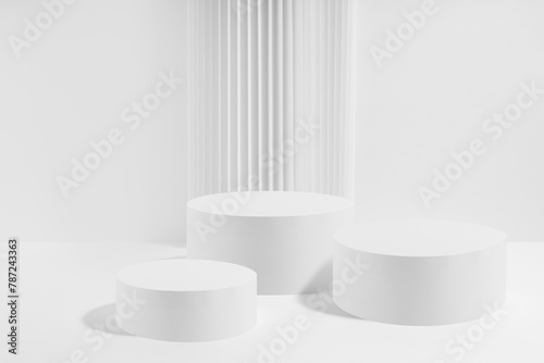 Three white round podiums with striped column as geometric decor, mockup on white background. Template for presentation cosmetic products, gifts, goods, advertising in contemporary black friday style.
