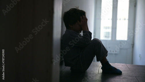 Wallpaper Mural Young Child Experiencing Family Crisis, Sitting Solitarily in Poorly Lit Hallway, Covering Face with Hands to Express Profound Grief and Sorrow Torontodigital.ca