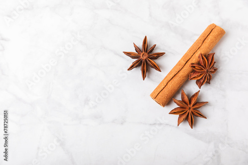 Fototapeta Naklejka Na Ścianę i Meble -  Cinnamon sticks and anise on a textured background. Cinnamon roll and star anise. Spicy spice for baking, desserts and drinks. Fragrant ground cinnamon.Place for text. copy space.