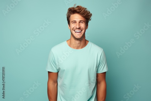 A man with a bright smile wearing a blue t-shirt exuding happiness and positivity