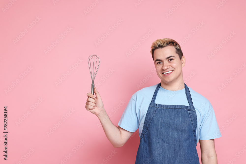 Portrait of happy confectioner holding whisk on pink background, space for text Portrait of happy confectioner holding whisk on pink background, space for text