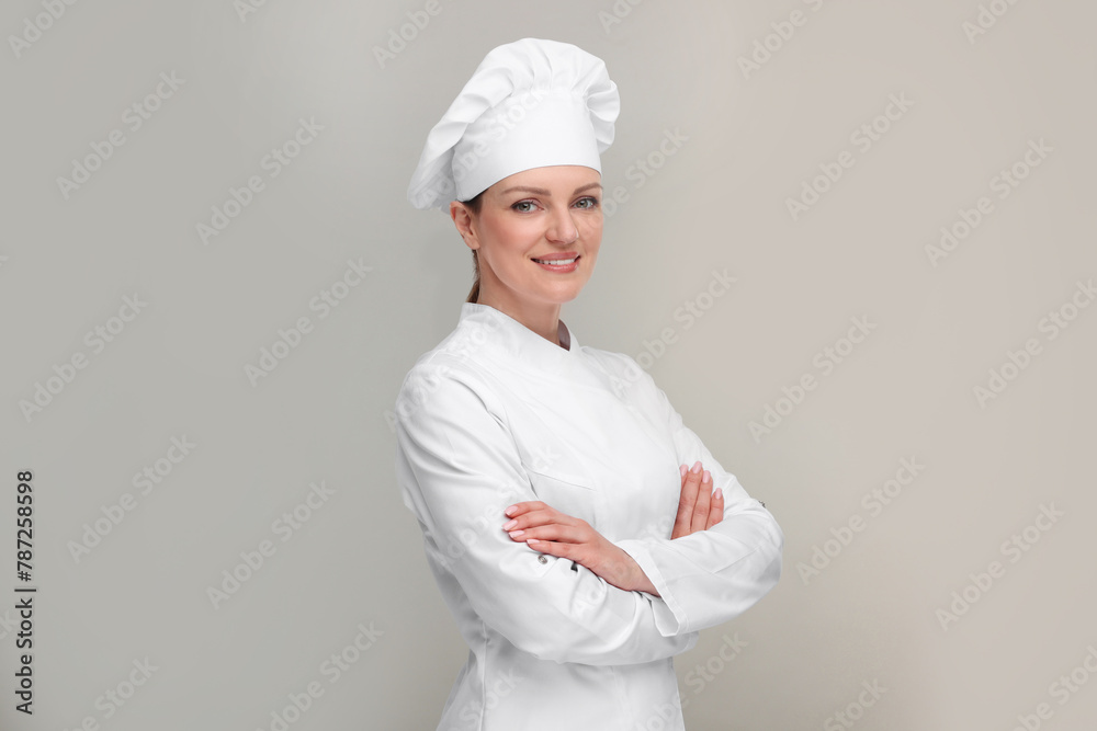 Happy chef in uniform on grey background Happy chef in uniform on grey background