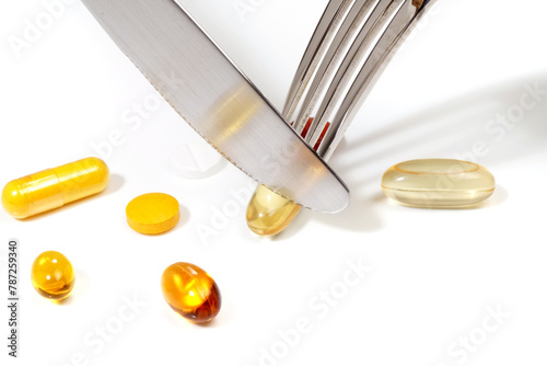 Eat pills with fork and knife on a white background