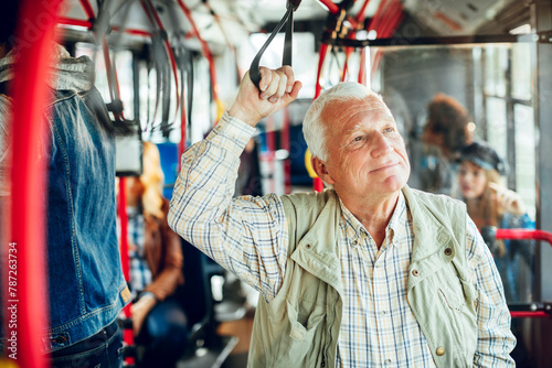 Senior man riding public bus and looking out window photo