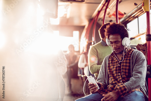 Young man on the bus with smartphone and headphones