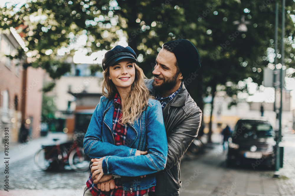 Stylish young couple walking and smiling on a city street Stylish young couple walking and smiling on a city street