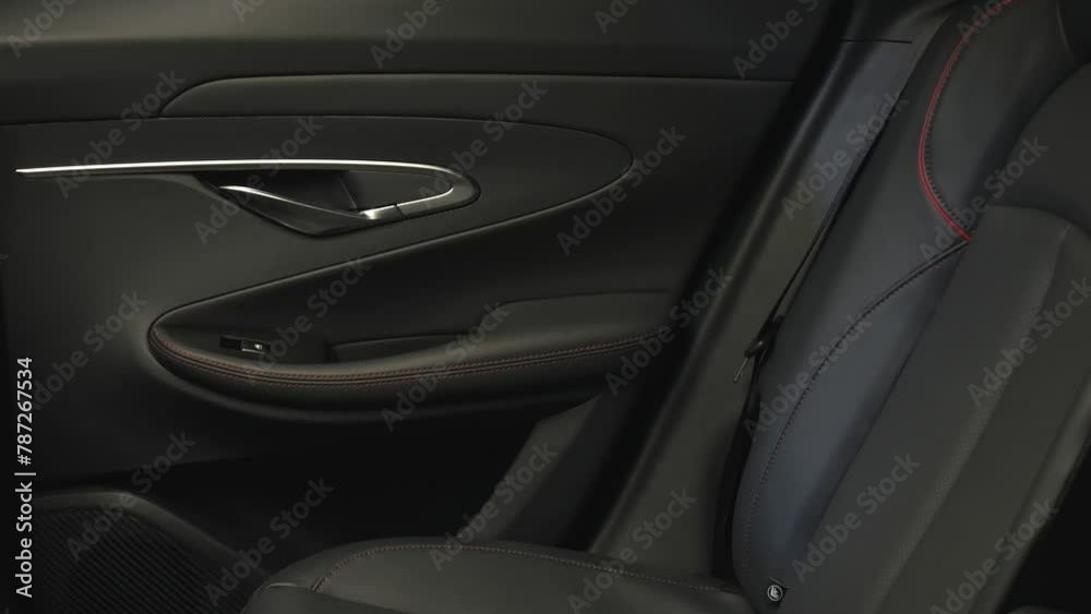 The camera slowly moves around the black interior of a premium car. View of the rear seats The camera slowly moves around the black interior of a premium car. View of the rear seats