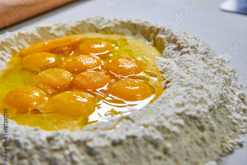 Fresh Egg Yolks in Flour for Homemade Pasta Preparation Close-Up