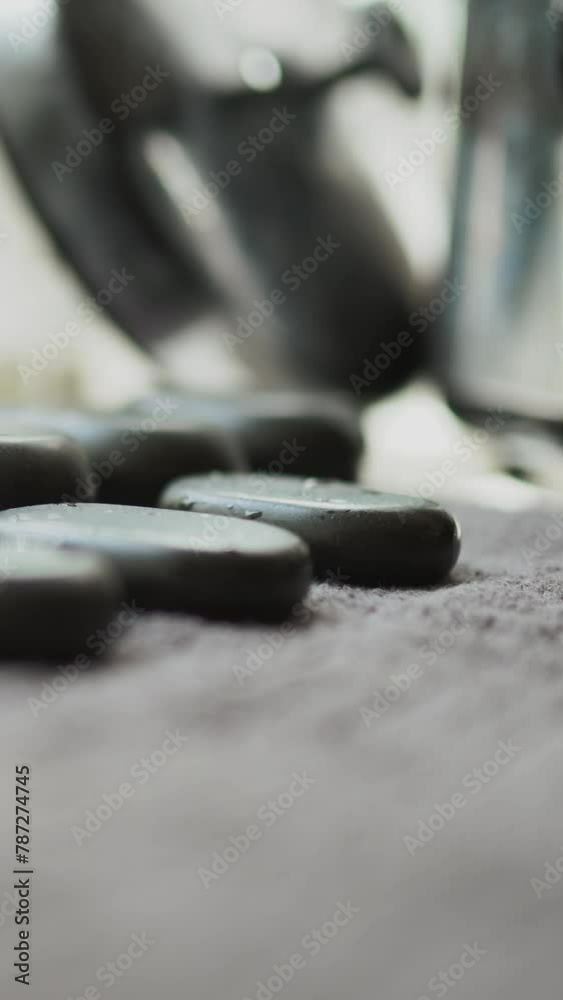 Massager woman makes hot stones massage warming up and relaxing back muscles to client girl lying on table. Beautiful girl client in therapy rests Massager woman makes hot stones massage warming up and relaxing back muscles to client girl lying on table. Beautiful girl client in therapy rests