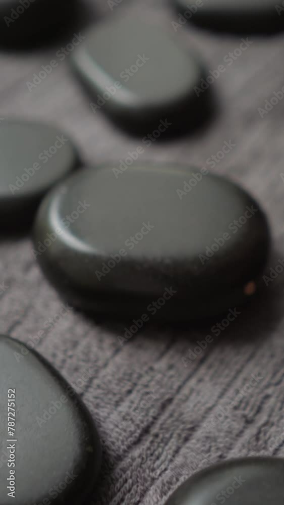 Massager woman makes hot stones massage warming up and relaxing back muscles to client girl lying on table. Beautiful girl client in therapy rests Massager woman makes hot stones massage warming up and relaxing back muscles to client girl lying on table. Beautiful girl client in therapy rests