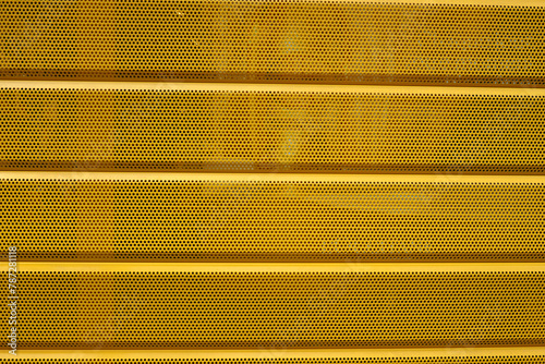 Grille métallique jaune de protection sur un magasin