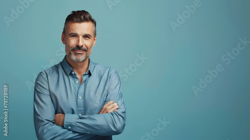 Handsome middleaged man standing with his arms folded looking at camera and smiling Halflength front portrait against blue background with copy space : Generative AI