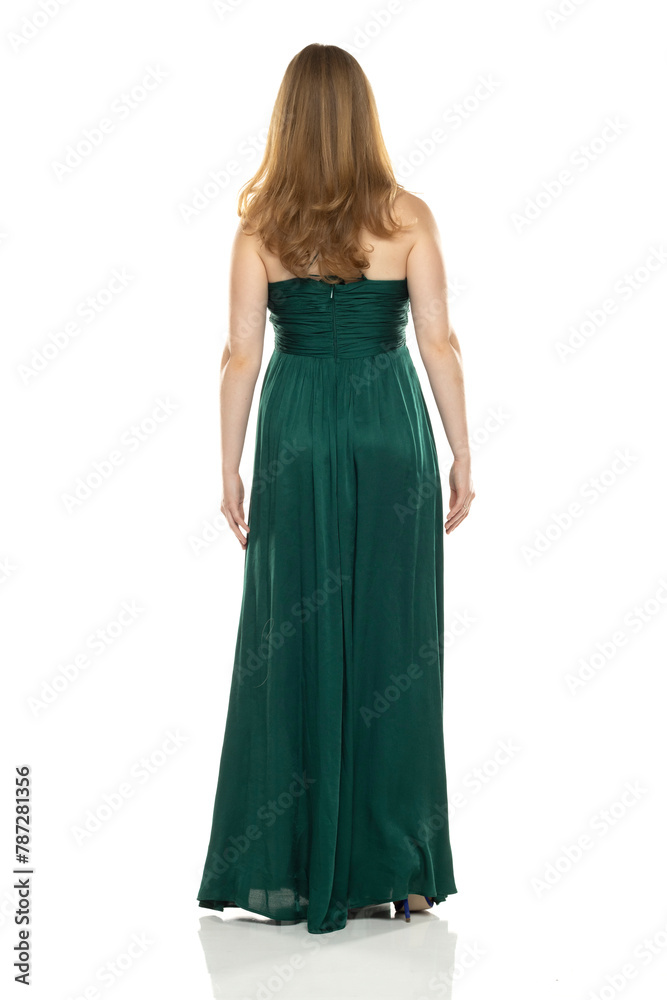 Full body rear view portrait of elegant lovely blond lady  posing isolated on white background in green long dress