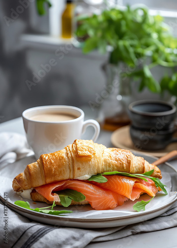 Croissant sandwich with salmon with coffee for breakfast, morning soft light on the kitchen