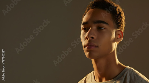 Young biracial man looks thoughtfully to the side with copy space his expression suggests contemplation or anticipation in a neutral setting : Generative AI