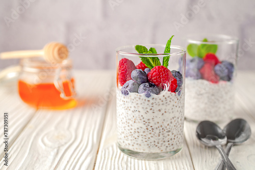 Healthy vanilla chia pudding in a glass with fresh berries and honey