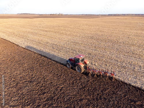 Aerial shot of tractor, ploughing field, made with drone. Farming, cultivating the land, machinery concepts
