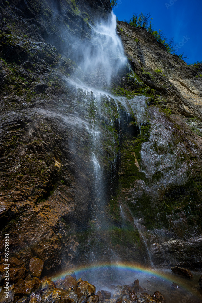 Waterfall hidden inside the forest, beauties of Slovenia to be discovered. Near Nova Gorica, Tolmin village. Water spray and vivid rainbow forms from the waterfall that falls sheer onto the rock. Waterfall hidden inside the forest, beauties of Slovenia to be discovered. Near Nova Gorica, Tolmin village. Water spray and vivid rainbow forms from the waterfall that falls sheer onto the rock.