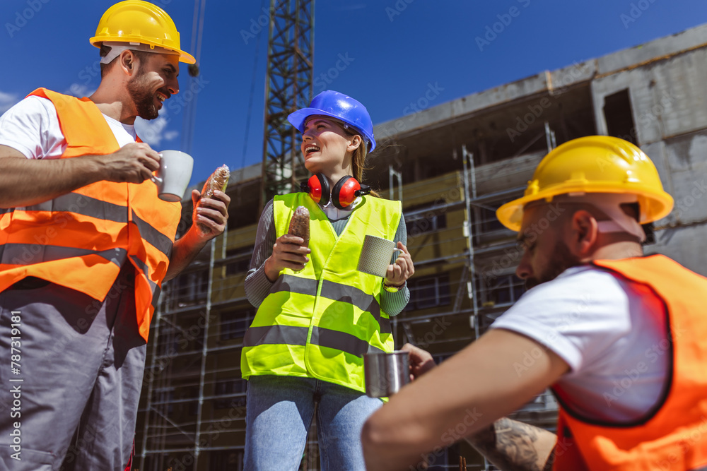 Three constructions workers having coffee and lunch break at construction site. Three constructions workers having coffee and lunch break at construction site.