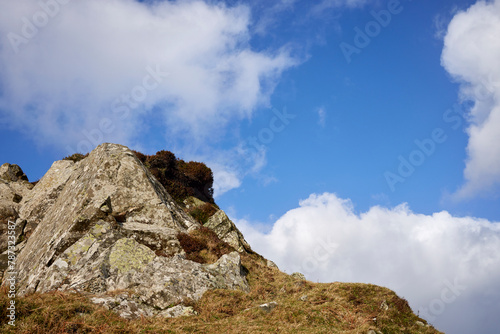 A rocky outcrop against a  blue sky with white clouds at Craignish Point. Ardfern, Argyll and Bute, Scotland photo