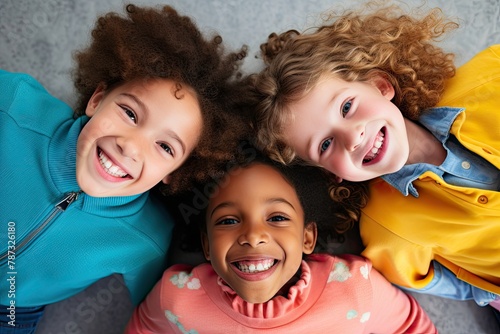 Happy smiling children in a circle looking down at the camera, bright colors, low angle shot from below with a top view, a portrait of joyful children playing and kids huddling, cute little children  photo