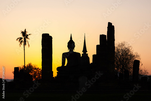 Sukhothai Historical Park. Thailand. Buddha silhouette and and ancient buddhist temple ruins at sunset. photo