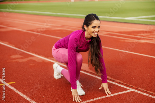 A sportswoman in start position on stadium.