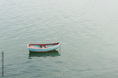 Colourful boat in the sea with milk bottle as a hand bailer photo