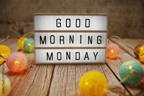 Good Morning Monday text on lightbox on wooden background photo