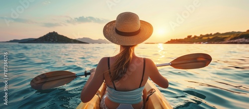 Woman kayaking in clean blue sea at sunset, outdoor active travel for a beautiful summer landscape © Nikolai
