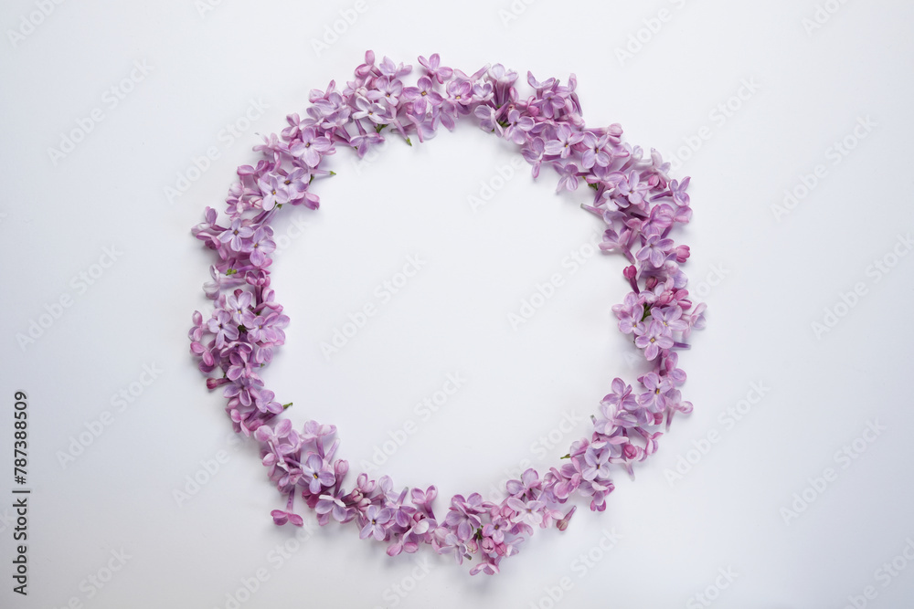 Round frame of lilac flowers isolated  on a white background. Top view, flat lay. Space for text.