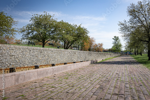 The pedestrian trail in Thoroughbred Park, Lexington, Kentucky, is paved with stones and bordered by a retaining wall.
