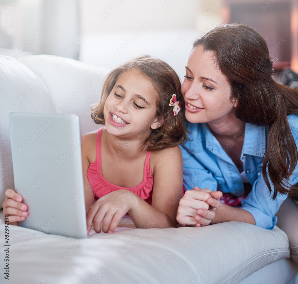 Mother, girl and kid on sofa with tablet for streaming, elearning or online games with bonding or together at family home. Happy, love and woman on break with daughter, connection and ebook with tech Mother, girl and kid on sofa with tablet for streaming, elearning or online games with bonding or together at family home. Happy, love and woman on break with daughter, connection and ebook with tech