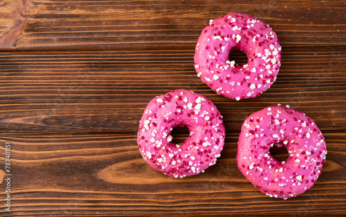 Set of colorful donuts on wooden background