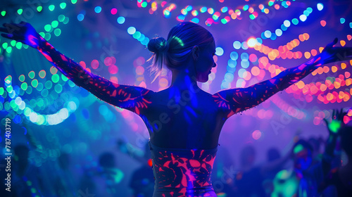 A woman with fluorescent bodypainting seen from back in a music event, dancing in neon color lights photo