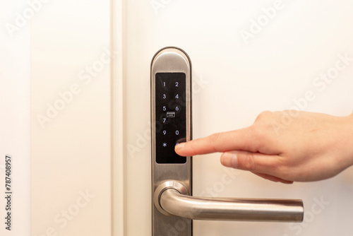 Close-up image of a person's finger entering a code on a security keypad to unlock a door, focusing on safety and privacy