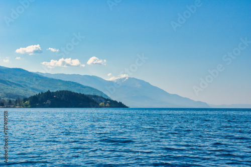 Lake Ohrid, North Macedonia, April 13 2024. Mountain range and peninsula in distance. Ohrid Lake, Macedonia, Europe. The clear mesmerizing waters of lake Ohrid with a beautiful view.  © Scotts Travel Photos