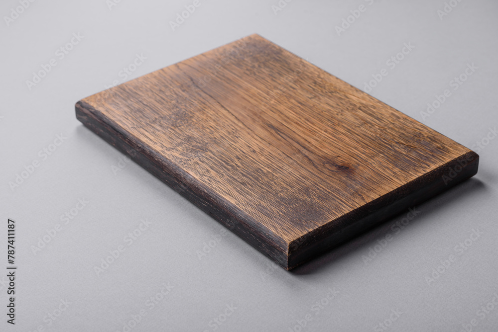 Empty wooden cutting board on gray textured concrete background Empty wooden cutting board on gray textured concrete background